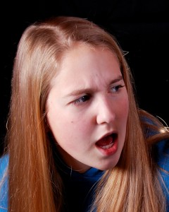 A young woman holding a card and looking outraged