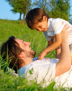 Happy childhool on green meadow, behind sunflower