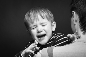 Portrait of a crying son on hands a father