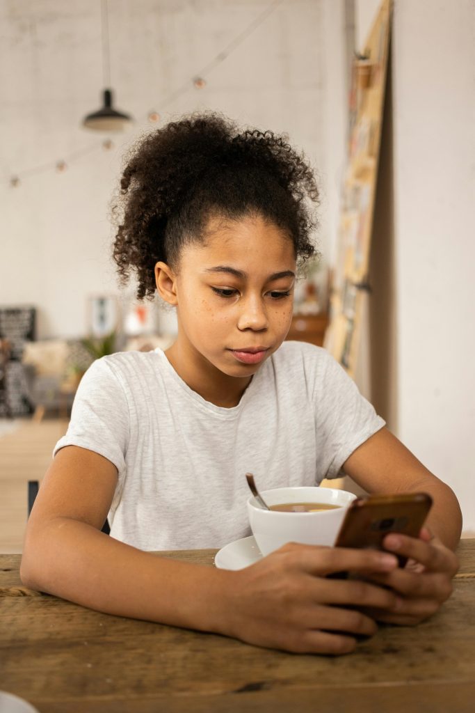 young teenage girl looking at her phone screen.